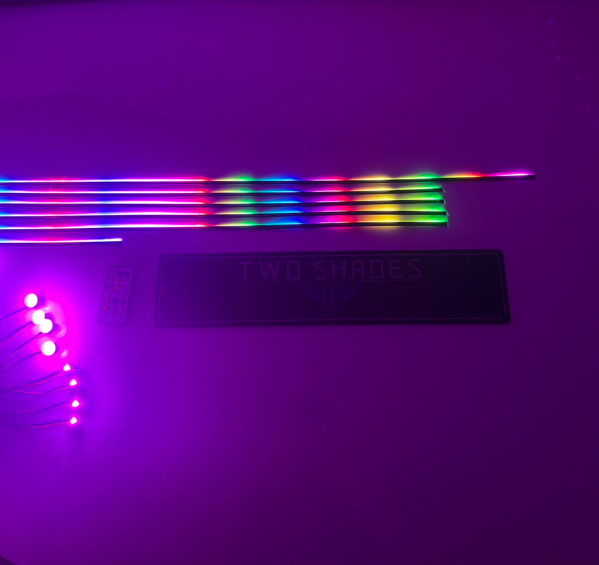 “Universal ambient lighting kit components: multi‑zone RGB LED strips, LED modules, RF remote and Two Shades London logo plate”